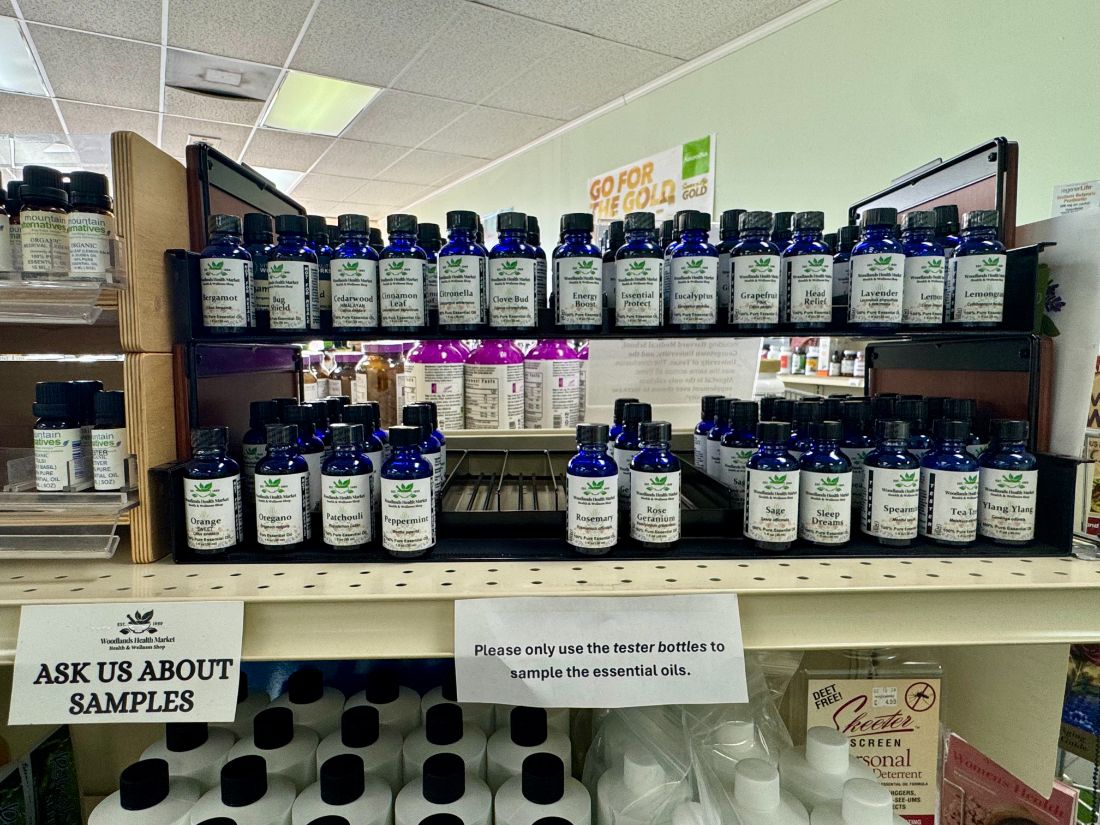 A rack of house-label essential oils with tester bottles