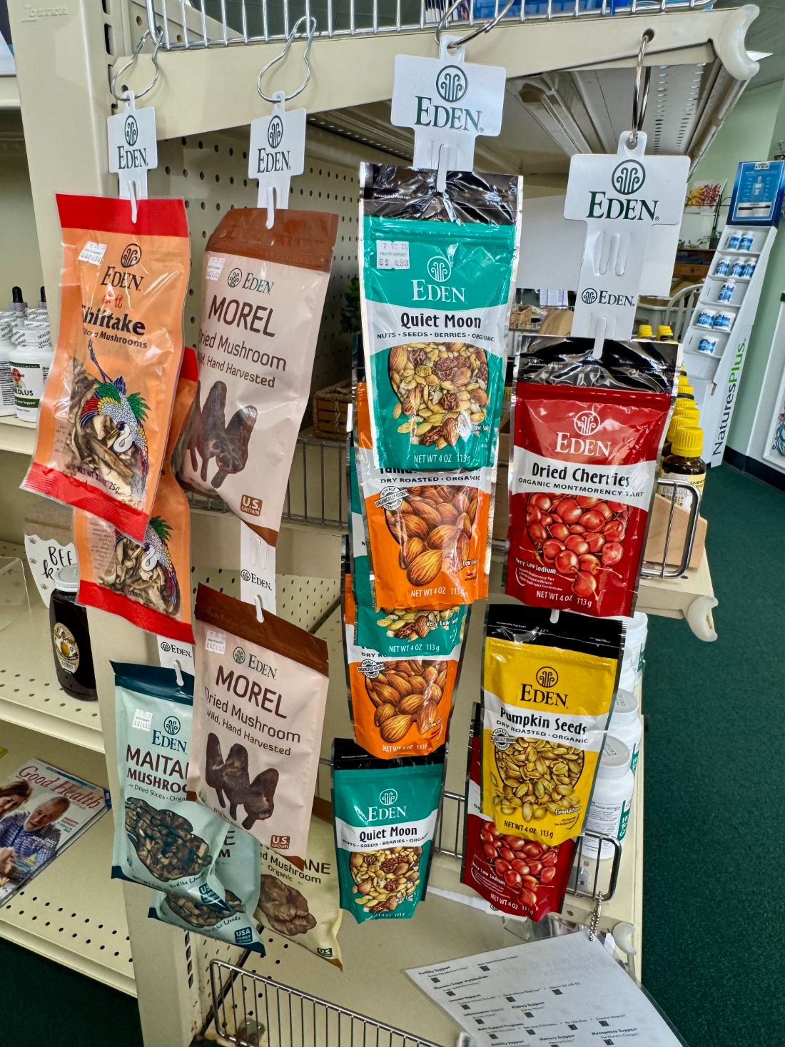 Bags of organic dried mushrooms, nuts and dried fruit on a hanging rack